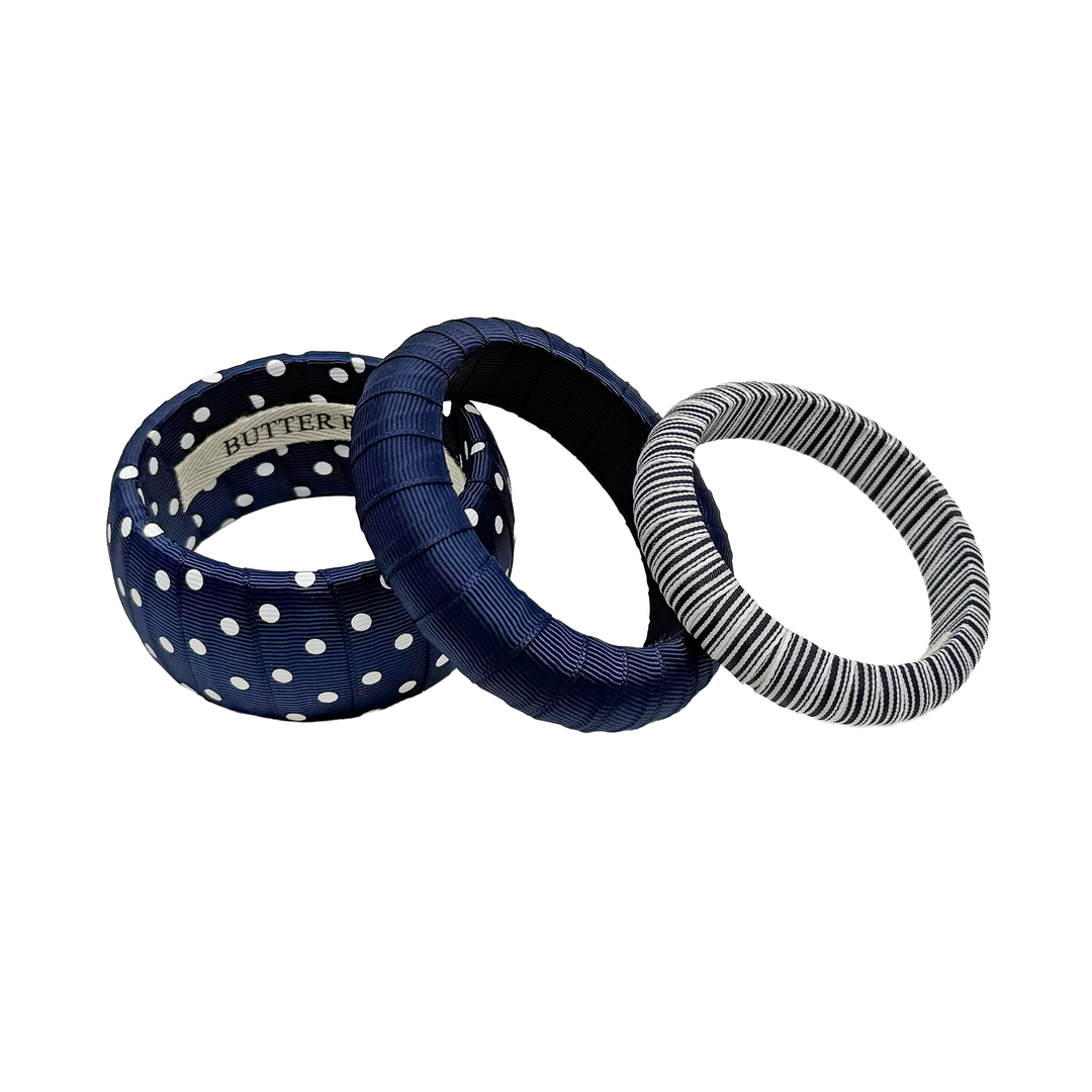 Three navy blue and white assorted Butter Republic bracelets; brand label affixed to the interior