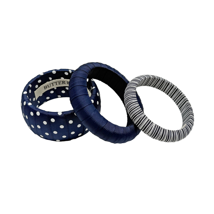 Three navy blue and white assorted Butter Republic bracelets; brand label affixed to the interior