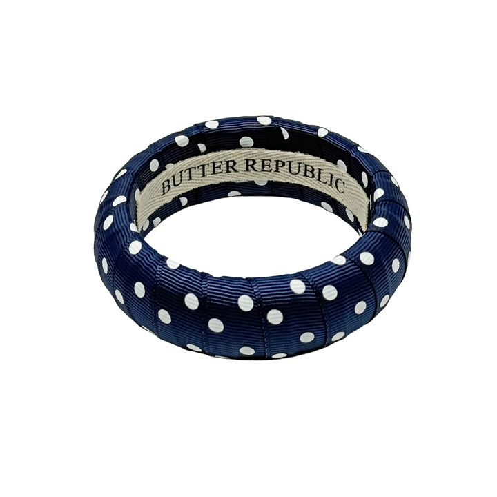 Navy blue and white polka dot bracelet Butter Republic brand label on the interior