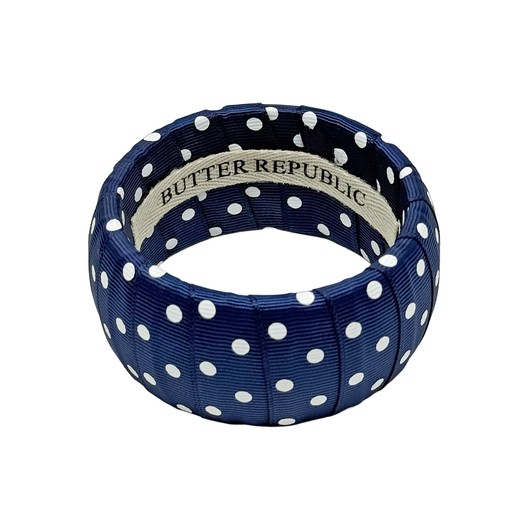 Navy blue and white polka dot bracelet with Butter Republic brand label on a white background