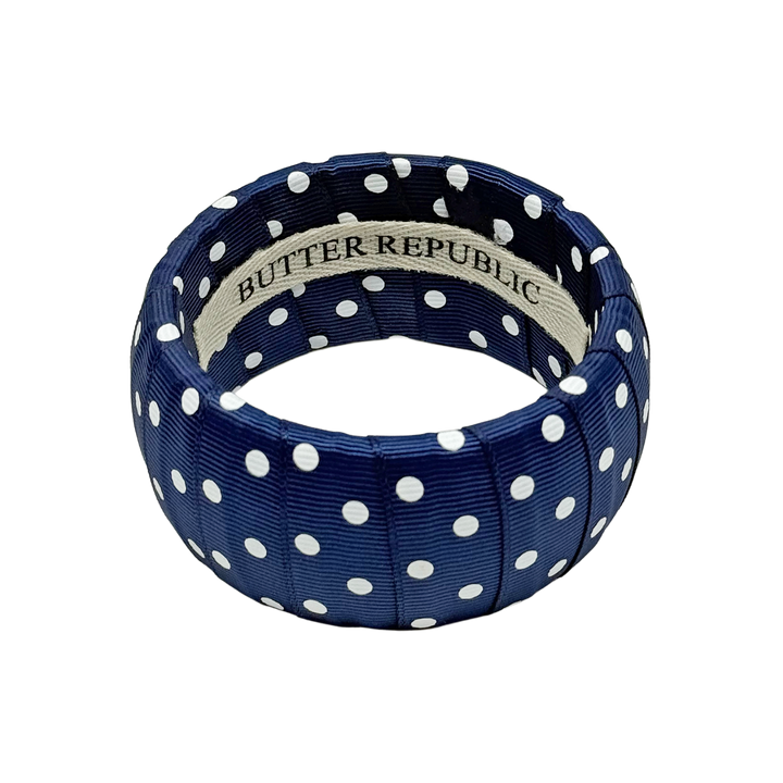 Navy blue and white polka dot bracelet with Butter Republic brand label on a white background