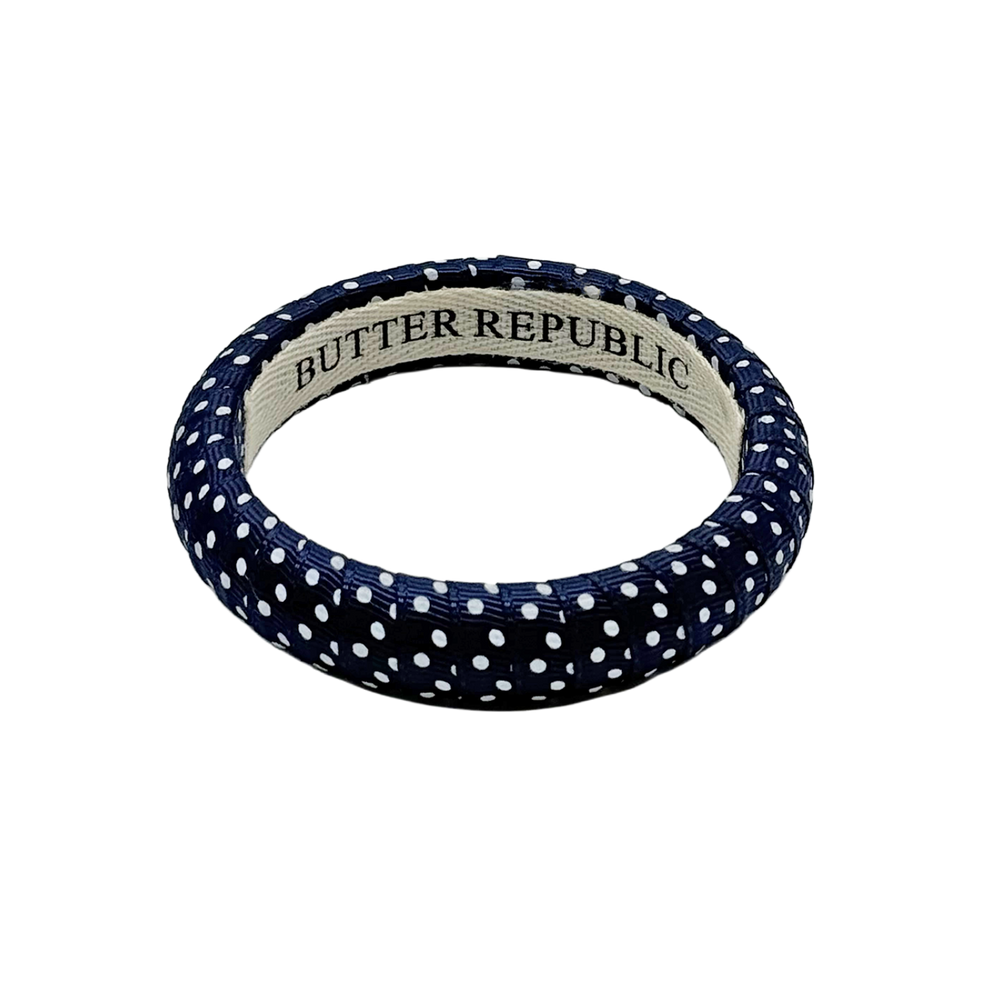 navy blue Swiss dots Butter Republic bracelet with logo brand label on the interior of the bracelet