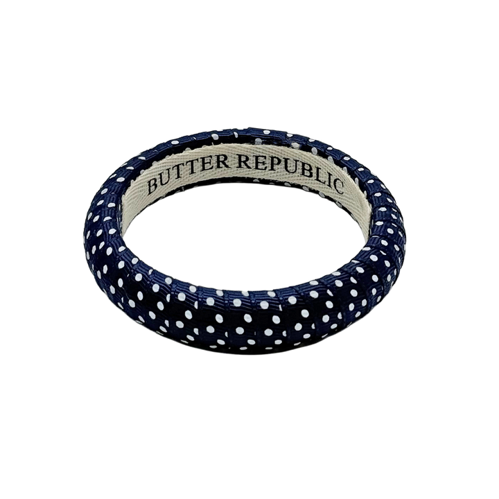 navy blue Swiss dots Butter Republic bracelet with logo brand label on the interior of the bracelet
