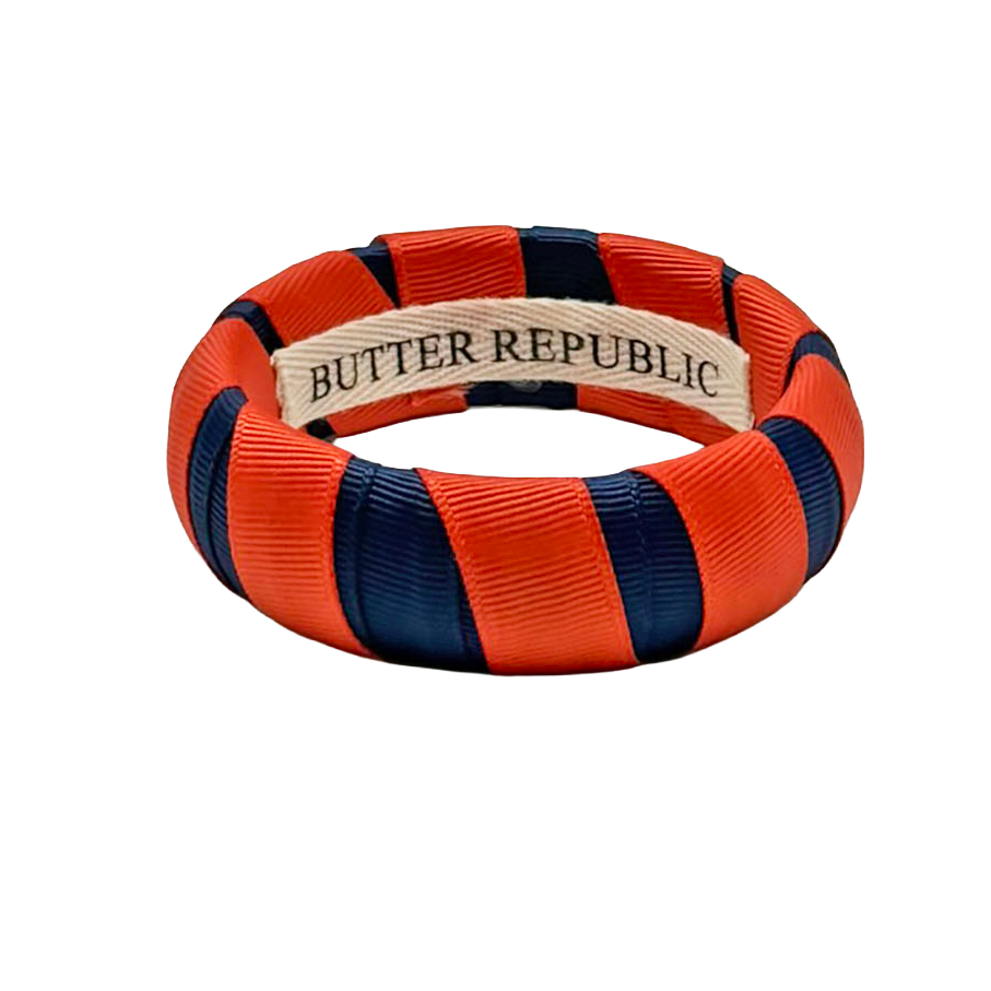 Orange and navy bracelet with 'Butter Republic' label affixed to the interior 