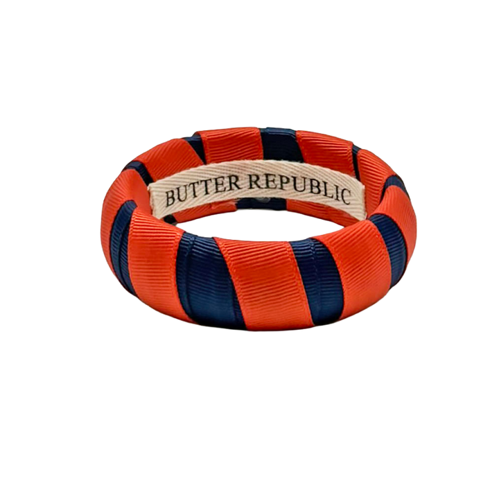 orange and navy Butter Republic bracelet with logo brand label on the interior of the bracelet