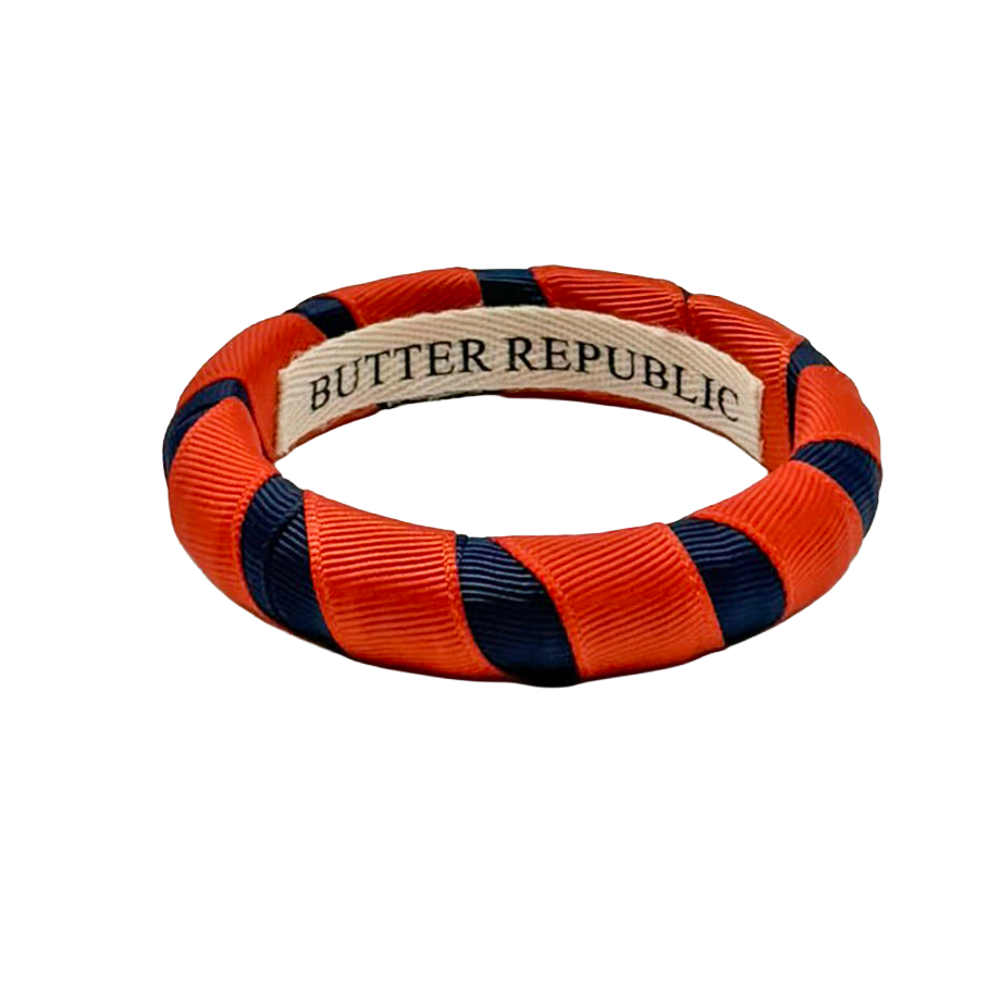 Butter Republic bracelet with orange and navy blue ribbon; Butter Republic logo affixed to the interior