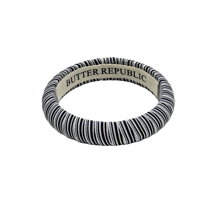 navy blue and white pinstripe Butter Republic bracelet with logo brand label on the interior of the bracelet