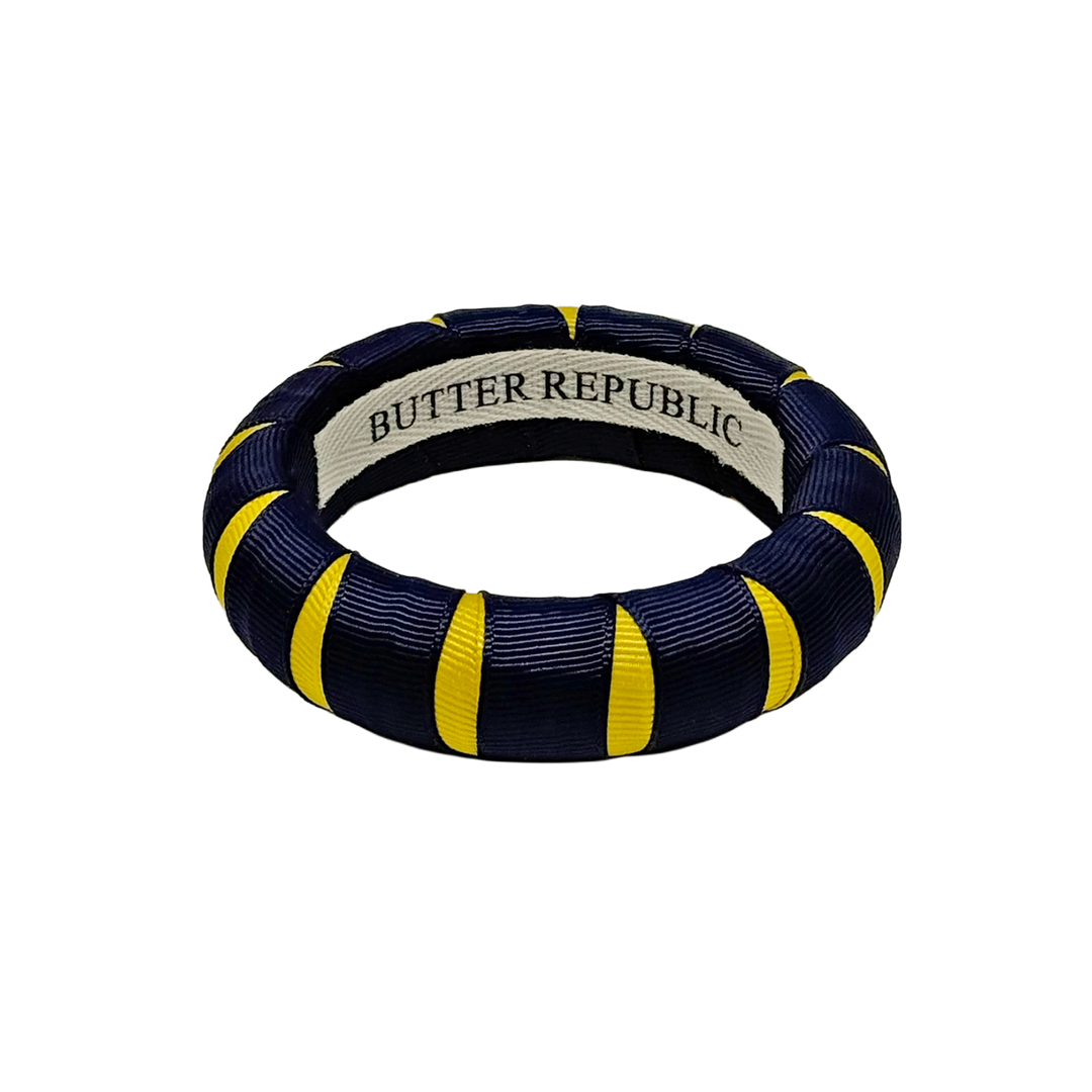 A navy blue and yellow Butter Republic bangle braceet