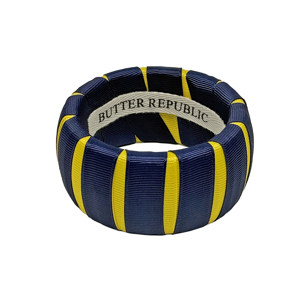 A wide navy blue and yellow Butter Republic bangle bracelet