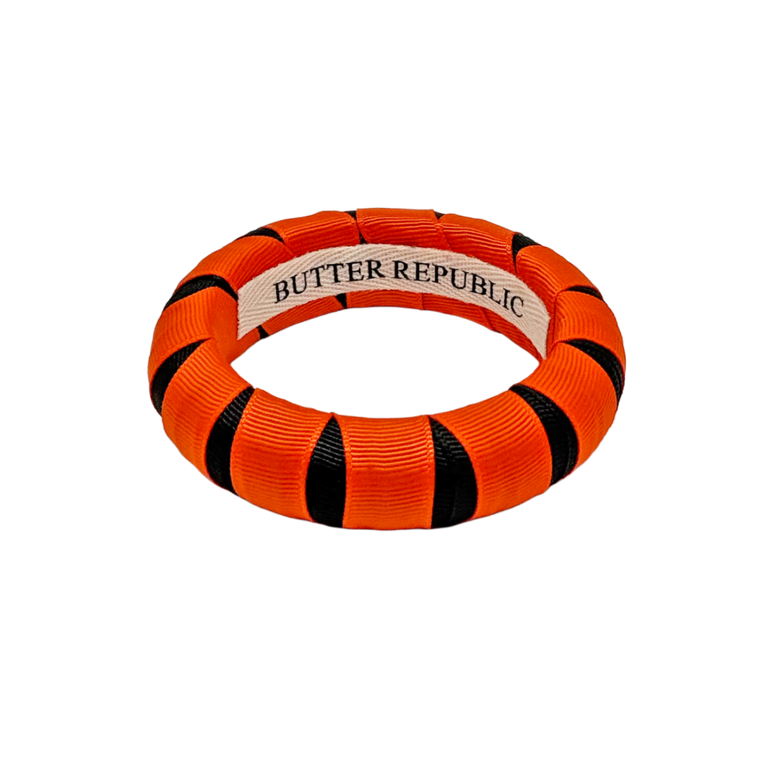 An orange and black Butter Republic bangle bracelet