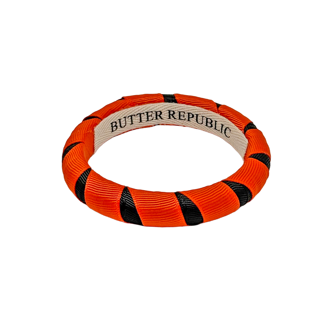 An orange and black Butter Republic ribbon-wrapped bracelet
