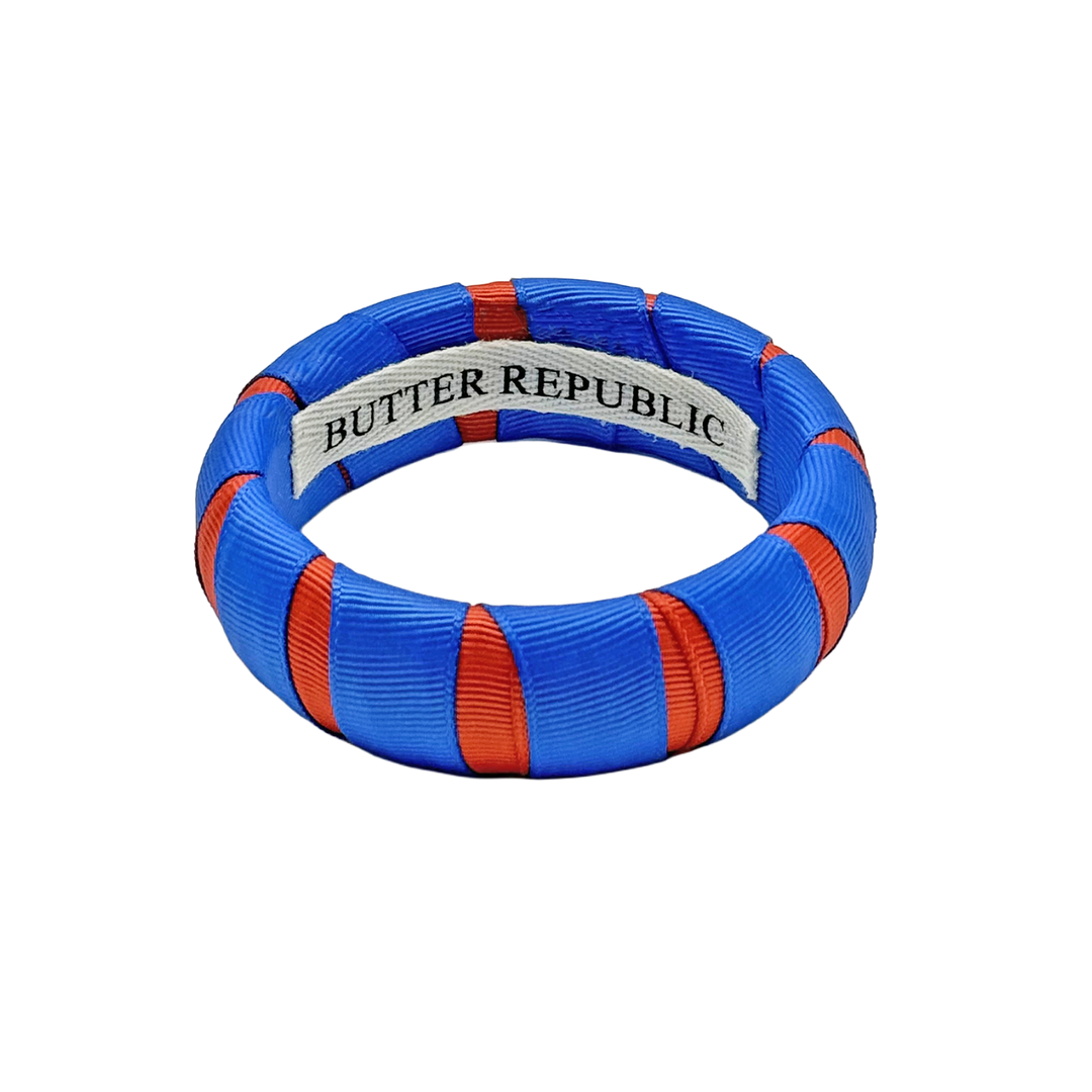 orange and blue Butter Republic bracelet with logo brand label on the interior of the bracelet