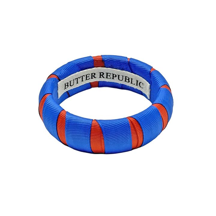 orange and blue Butter Republic bracelet with logo brand label on the interior of the bracelet