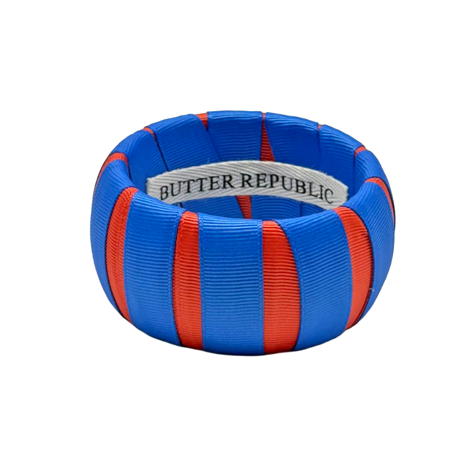 orange and blue Butter Republic bracelet with logo brand label on the interior of the bracelet