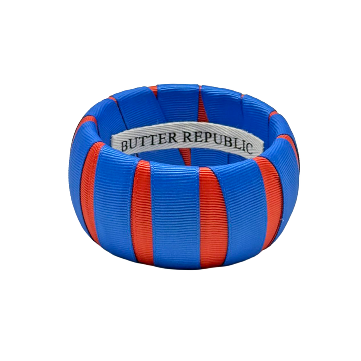 orange and blue Butter Republic bracelet with logo brand label on the interior of the bracelet