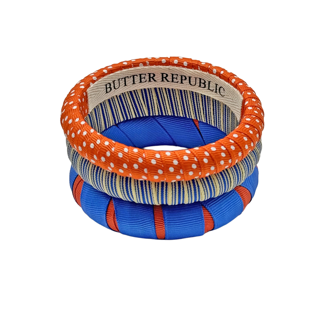 stack of three Butter Republic bracelets in orange and blue, with logo brand label on the interior of the bracelet
