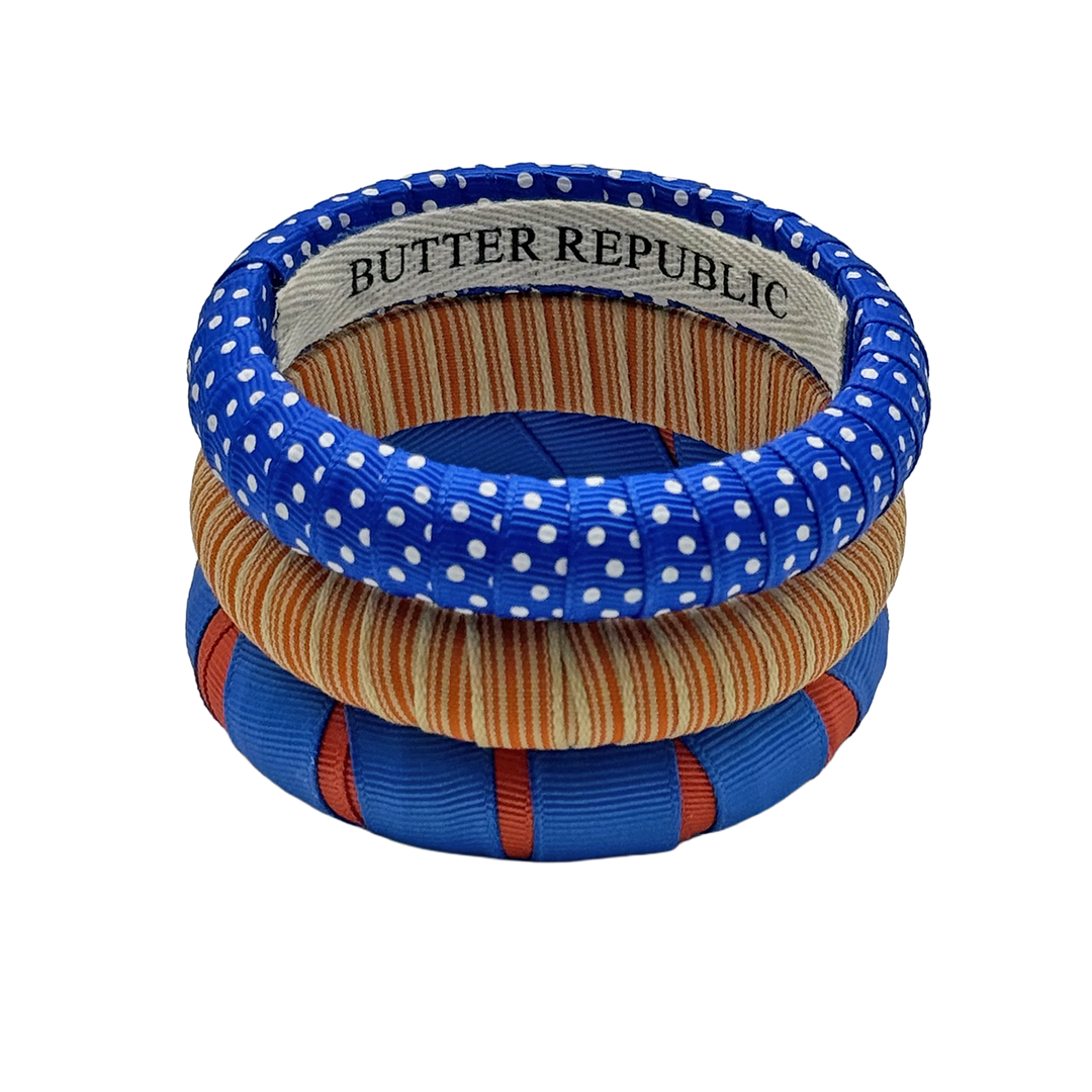 Three orange and blue bracelets with 'Butter Republic' branded on the interior