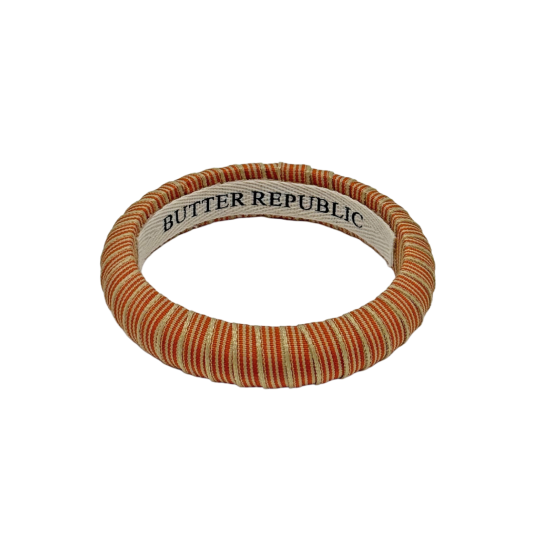 orange and cream pinstripe Butter Republic bracelet with logo brand label on the interior of the bracelet