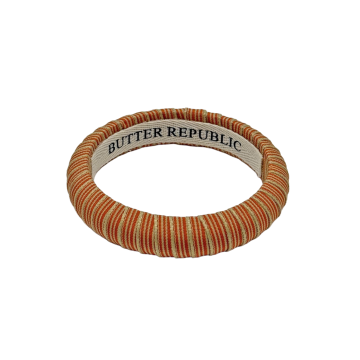 orange and cream pinstripe Butter Republic bracelet with logo brand label on the interior of the bracelet