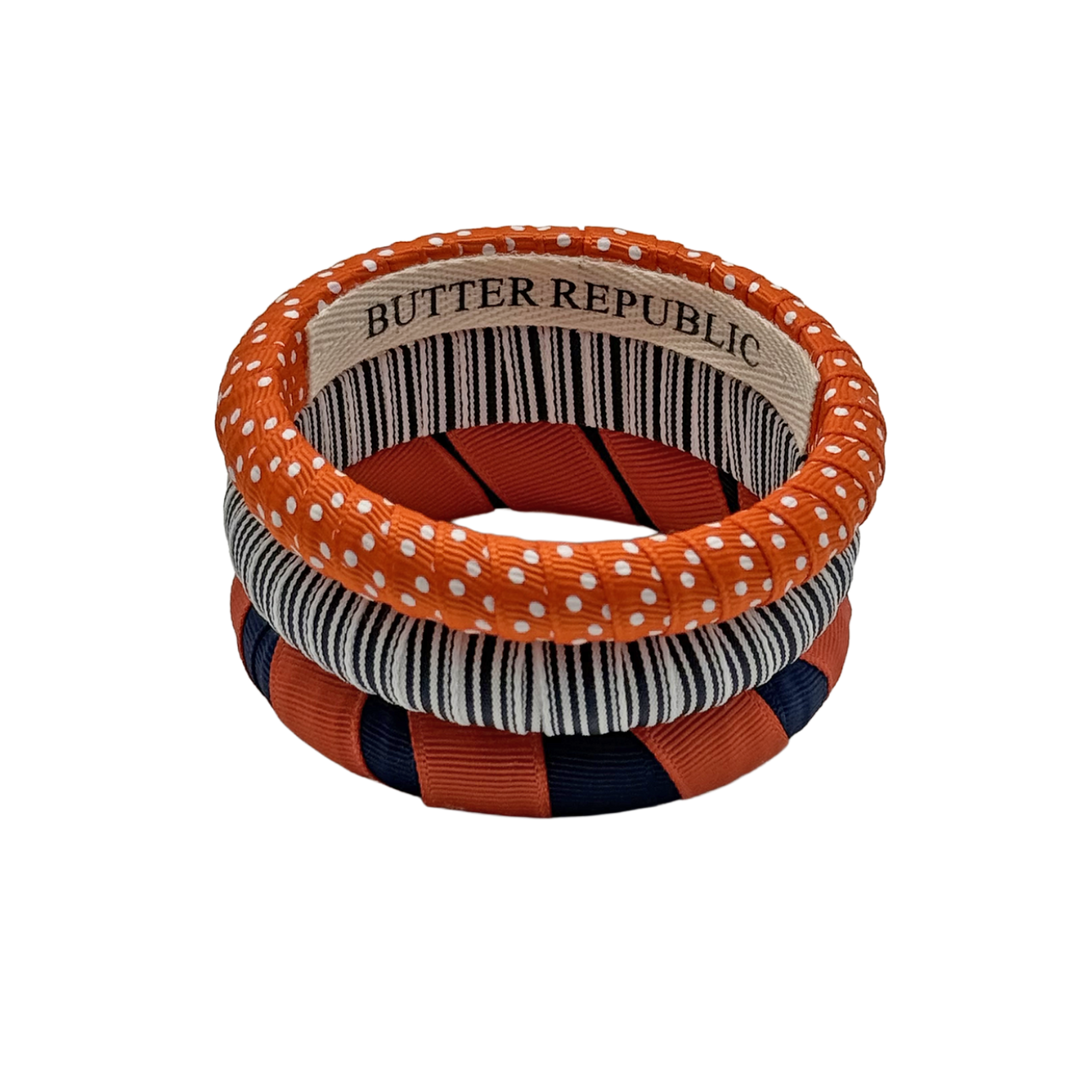set of three orange and navy blue Butter Republic bracelets with logo brand label on the interior of the bracelet