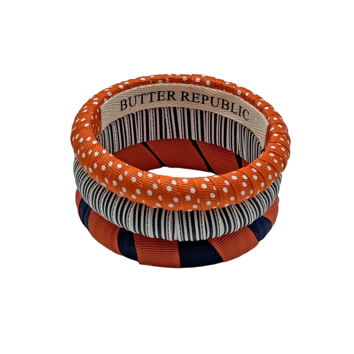 set of three orange and navy blue Butter Republic bracelets with logo brand label on the interior of the bracelet