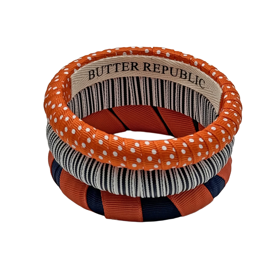Set of three orange and navy blue bracelets with 'Butter Republic' branding on the interior
