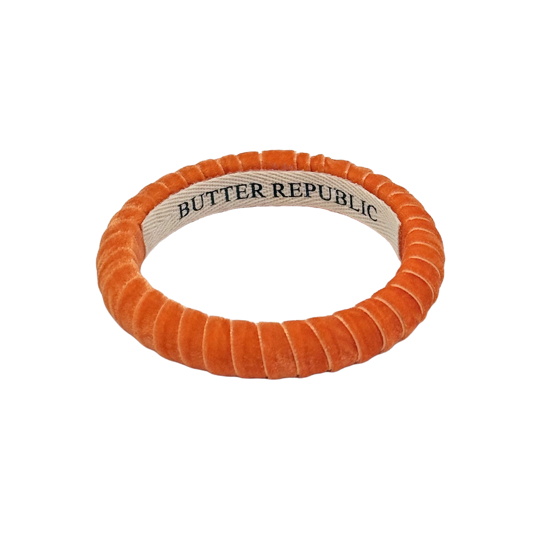 orange velvet Butter Republic bracelet with logo brand label on the interior of the bracelet