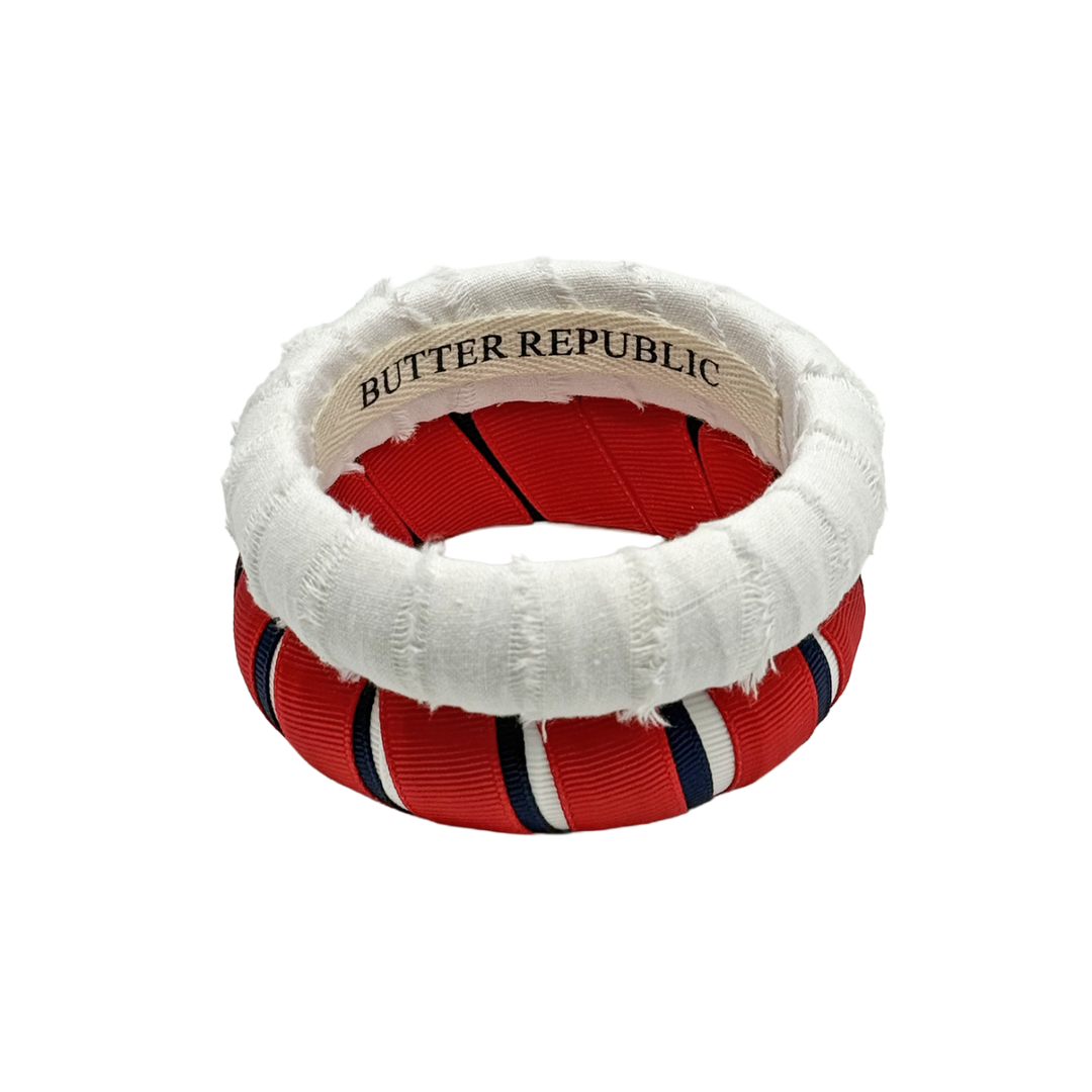 red, white, and navy blue pair of Butter Republic bracelets with brand labels on the interior of the bracelets