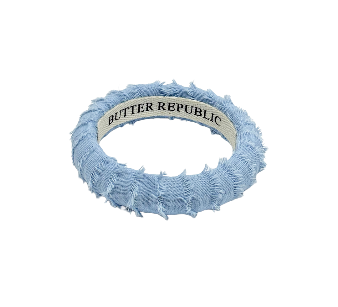 light blue denim powder blue Butter Republic bracelet with a brand label on the interior of the bracelet