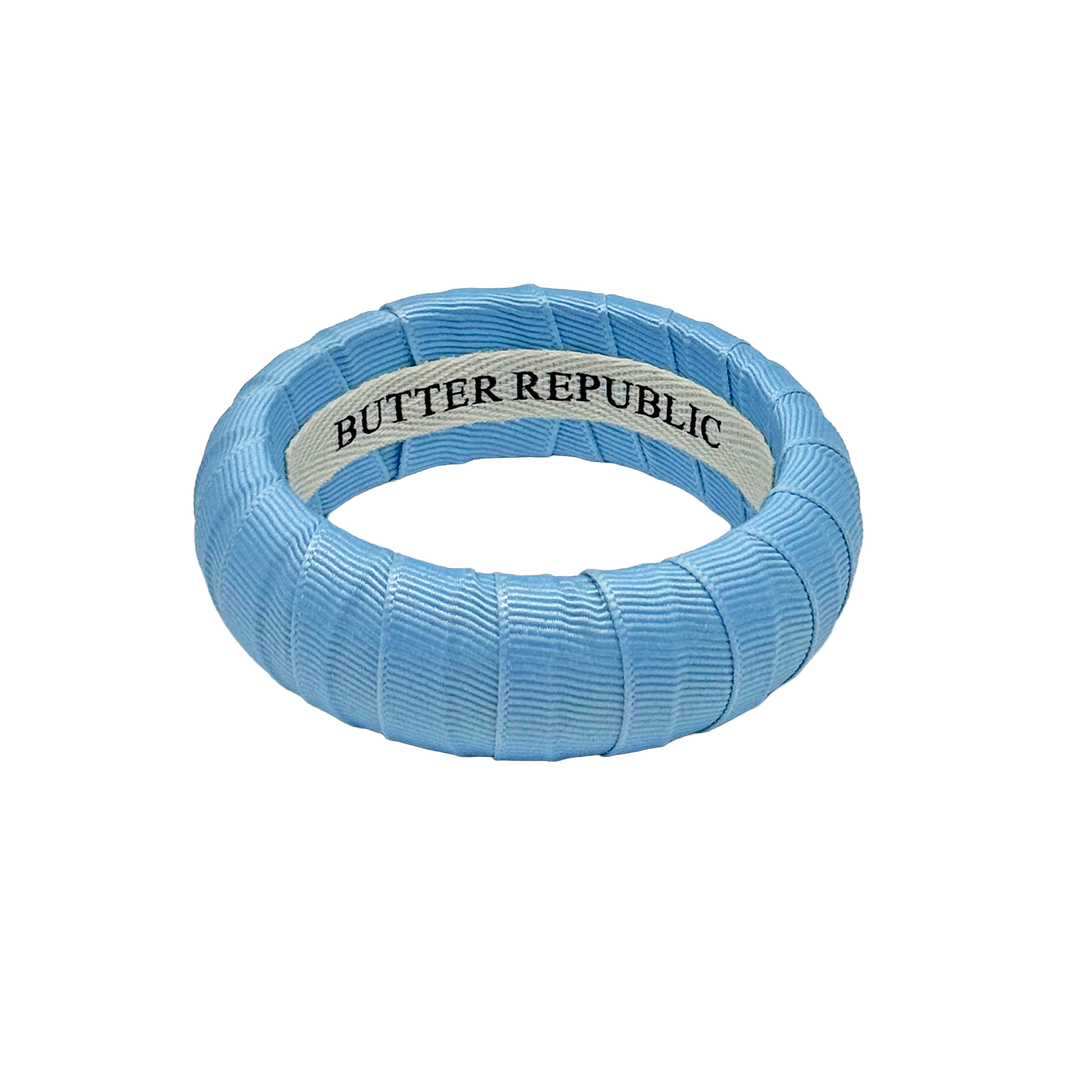 Light blue Butter Republic bangle bracelet with brand label on the interior