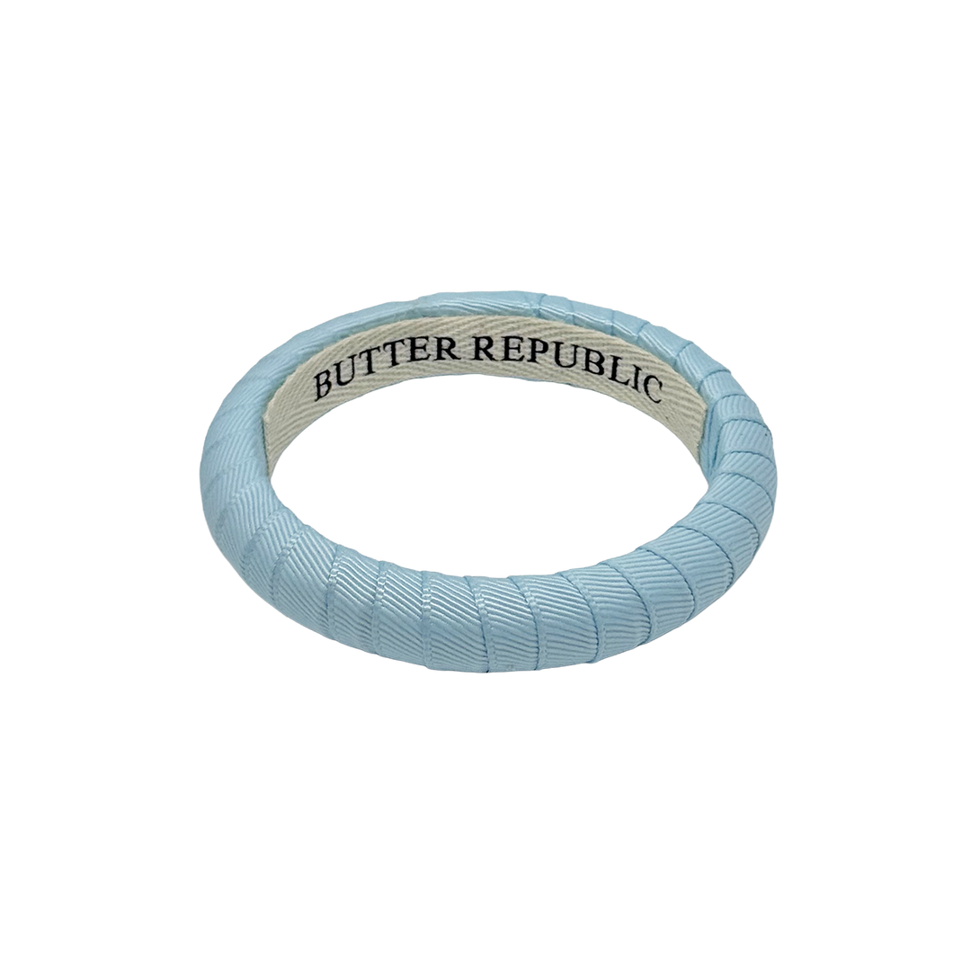 narrow powder blue Butter Republic bracelet with brand label on the interior