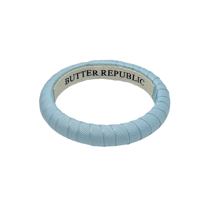 narrow powder blue Butter Republic bracelet with brand label on the interior