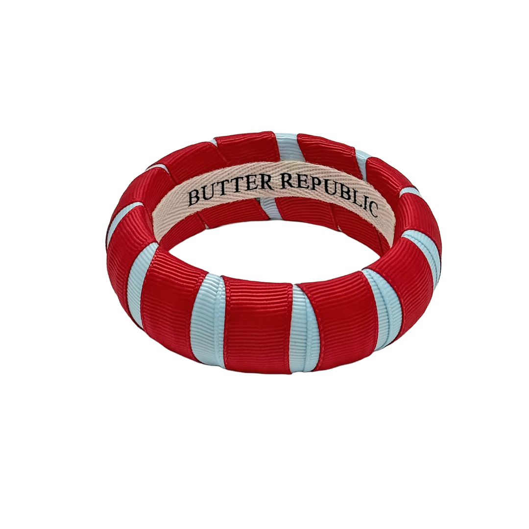 red and powder blue Butter Republic bracelet with a brand label on the interior of the bracelet