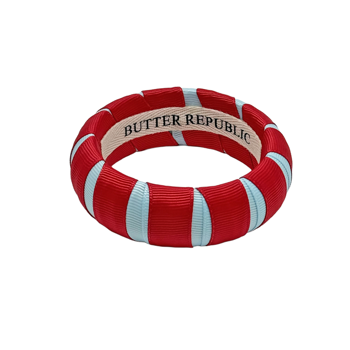 red and powder blue Butter Republic bracelet with a brand label on the interior of the bracelet