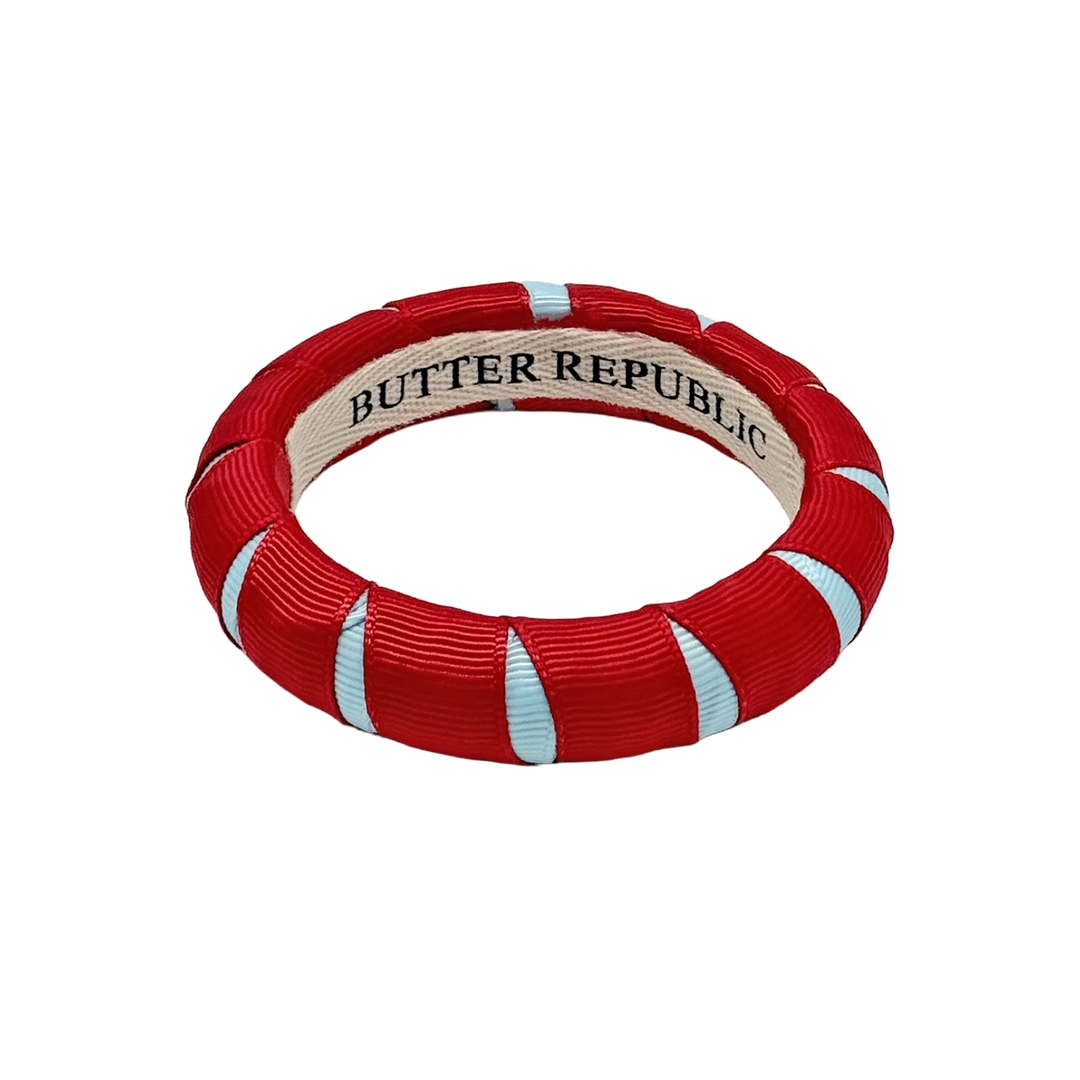 red and powder blue Butter Republic bracelet with a brand label on the interior of the bracelet