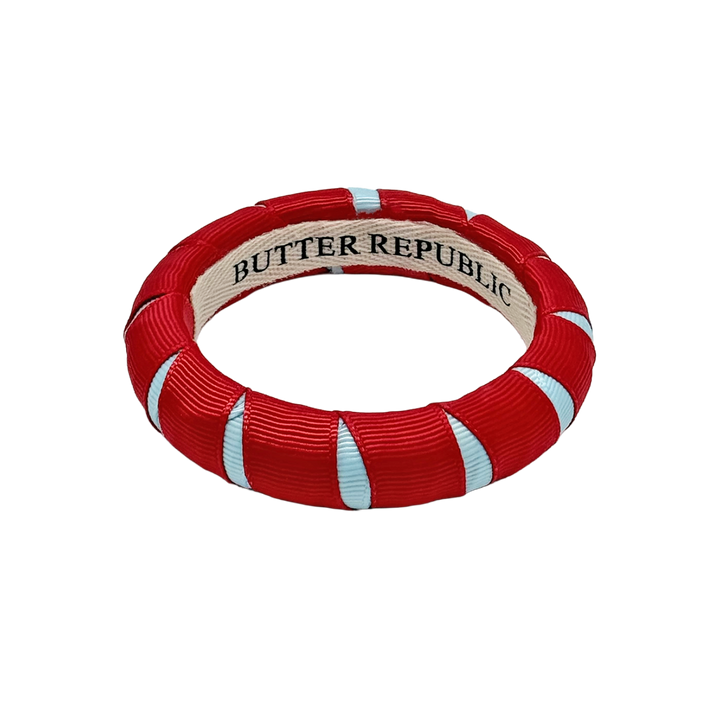 red and powder blue Butter Republic bracelet with a brand label on the interior of the bracelet