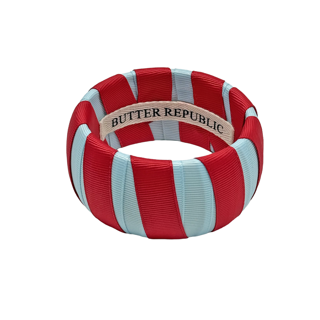 powder blue and red Butter Republic bracelet with a brand label on the interior of the bracelet