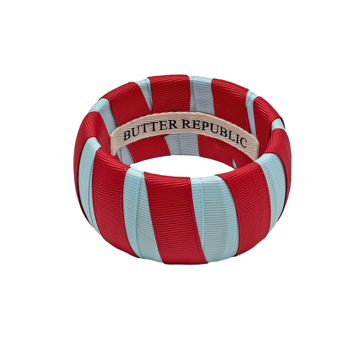 powder blue and red Butter Republic bracelet with a brand label on the interior of the bracelet
