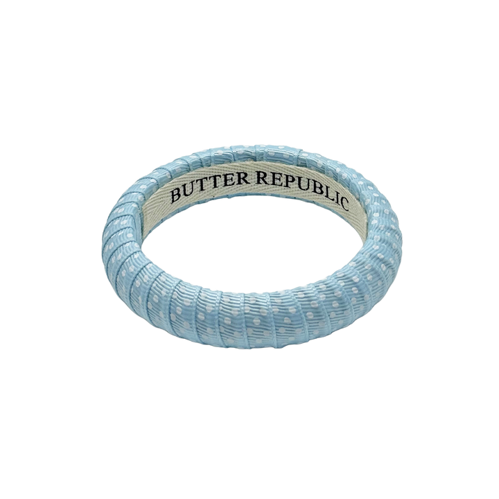 powder blue and white Swiss dots Butter Republic bracelet with white brand logo on the bracelet interior