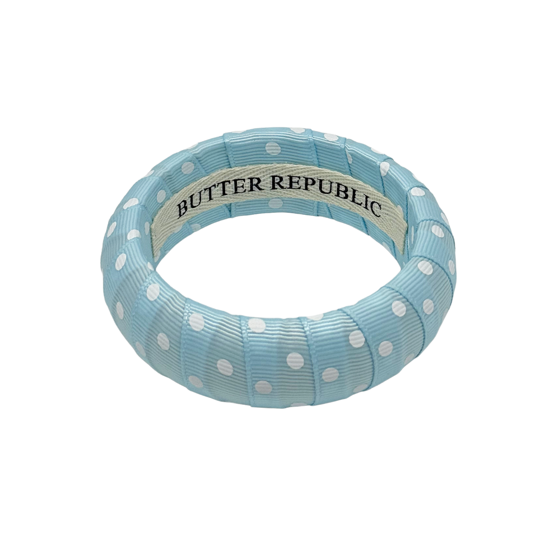 Powder blue and white polka dot bracelet with Butter Republic brand label on the interior