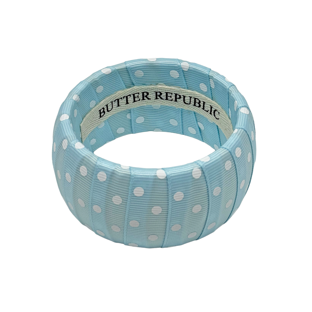 Powder blue and white polka dot bracelet with Butter Republic brand label on the interior