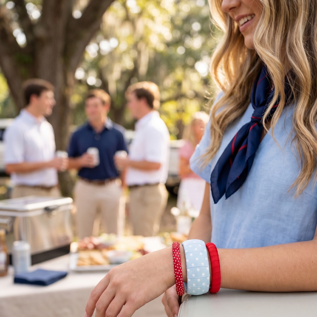 A young woman in a powder blue dress, wearing a Butter Republic stack of blue and red bracelets at a tailgate party