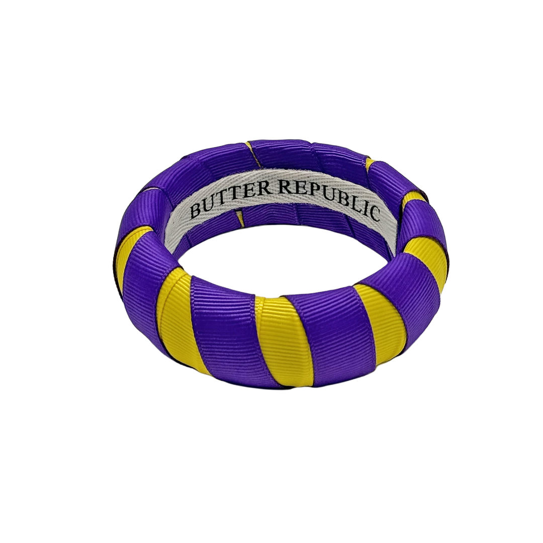 purple and gold Butter Republic bracelet with a brand label on the interior of the bracelet