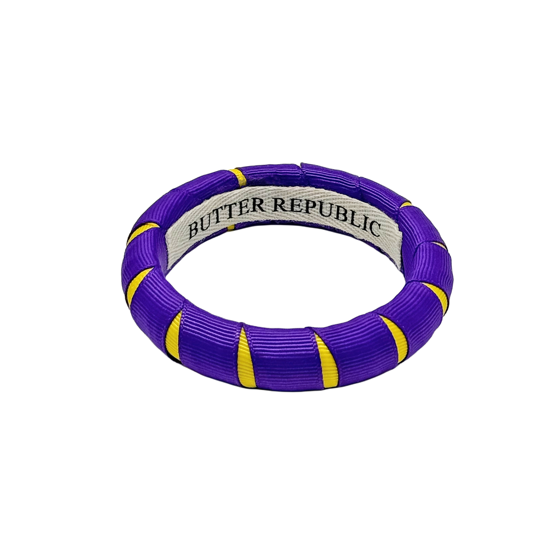 purple and gold Butter Republic bracelet with a brand label on the interior of the bracelet