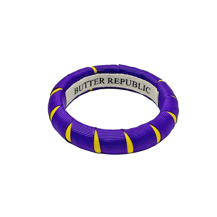 purple and gold Butter Republic bracelet with a brand label on the interior of the bracelet