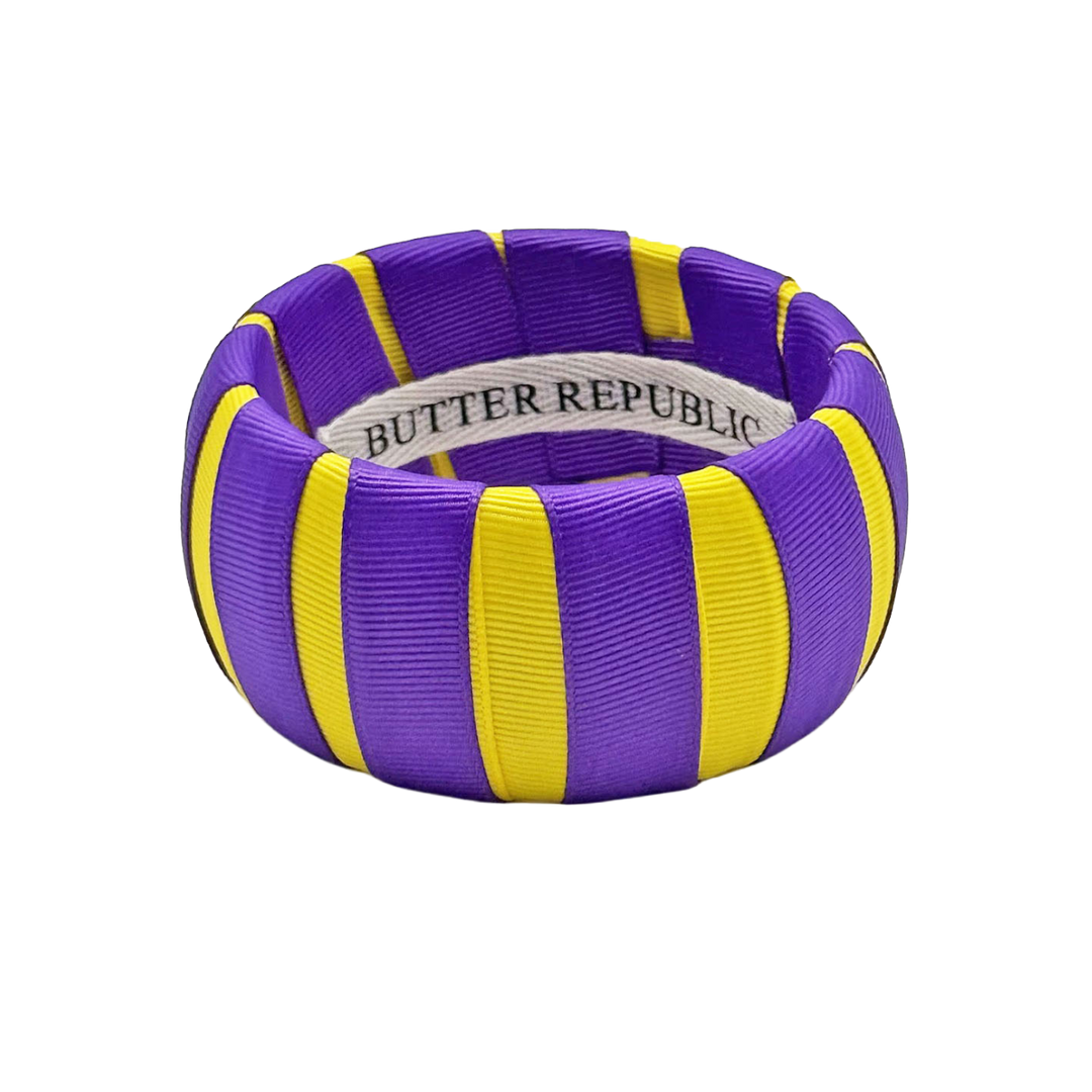 wide purple and yellow Butter Republic bracelet with a brand label on the interior of the bracelet