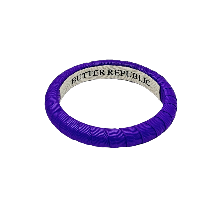 purple narrow Butter Republic bracelet with brand name on an interior label