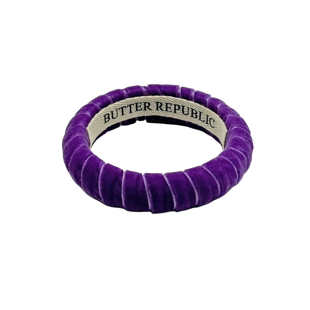 purple velvet Butter Republic bracelet with a brand label on the interior of the bracelet