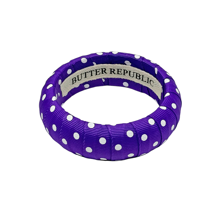 Purple and white polka dot bracelet with Butter Republic brand label on the interior