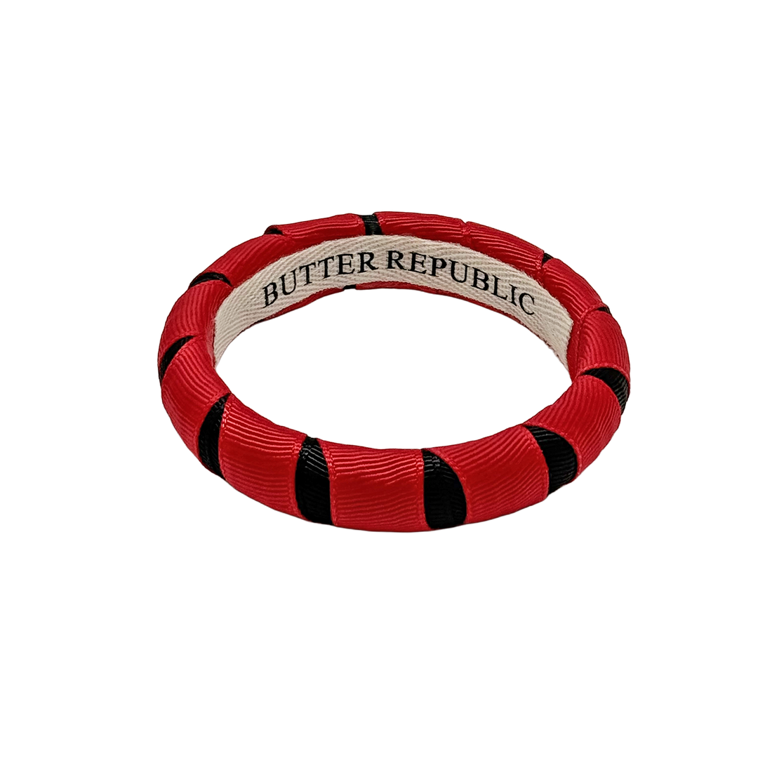 red and black Butter Republic bracelet with a brand label on the interior of the bracelet